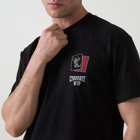 Model wearing Carhartt Playing Cards Logo T-Shirt in black, showing chest graphic with playing card and Carhartt WIP logo detail.
