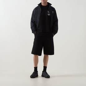 Model wearing Carhartt Playing Cards Logo T-Shirt in Black, styled with black zip jacket, shorts, and chunky trainers.