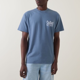 Model wearing Carhartt Formidable Logo T-Shirt in Shady Blue, crew neck with chest logo, styled with light wash jeans.