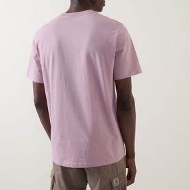 Model wearing Carhartt Pocket Logo T-Shirt in Hortensia purple, rear view, crew neck, short sleeves, styled with beige cargo trousers.