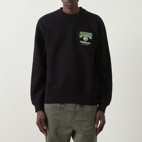 Model wearing Carhartt Pinball Logo Sweatshirt in Black, crew neck with chest graphic, styled with khaki trousers