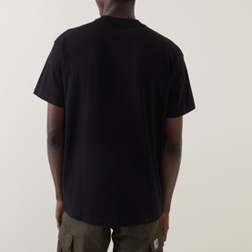 Model wearing Carhartt Please Don't Snitch Logo T-Shirt in black, rear view, crew neck, short sleeves, paired with khaki cargo trousers