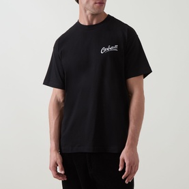 Model wearing Carhartt Pup Logo T-Shirt in black with crew neck, short sleeves, and white script logo graphic on chest.