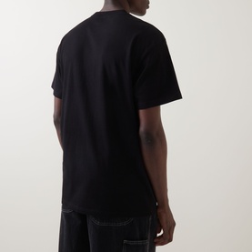 Model wearing Carhartt Gracious Logo T-Shirt in black, rear view, crew neck, dropped shoulders, short sleeves, styled with dark denim jeans.