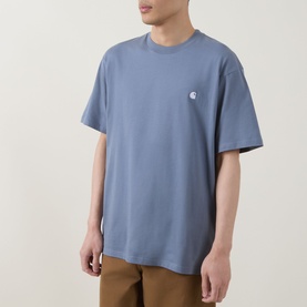 Model wearing Carhartt crew neck T-shirt in Shady Blue with small chest logo, styled with tan trousers.