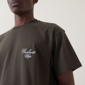 Model wearing Carhartt Gracious Logo T-Shirt in Cypress, featuring white script chest embroidery, crew neck, and dropped shoulders.