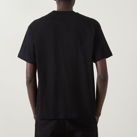 Model wearing Carhartt Coordinates Logo T-Shirt in black, rear view, showing dropped shoulders, short sleeves, and straight hem.