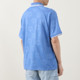 Model wearing Carhartt Terrace Logo Football T-Shirt in Curacao blue with all-over heart print, white-tipped polo collar, paired with light wash