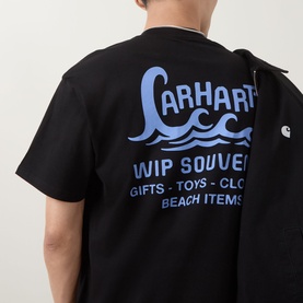 Model wearing Carhartt Waves Logo T-Shirt in black, showing back graphic print with wave motif and WIP Souvenir text in blue.