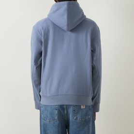 Model wearing Carhartt American Script Logo Hoodie in Shady Blue, rear view, with blue jeans. Drawstring hood, ribbed hem, kangaroo pocket.