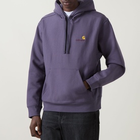 Model wearing Carhartt American Script Logo Hoodie in Shady Purple with kangaroo pocket and embroidered chest logo, styled with dark jeans