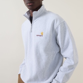 Model wearing Carhartt American Script Logo Half-Zip Sweatshirt in Ash Heather, with funnel neck, half-zip placket and chest logo embroidery.