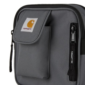 Carhartt crossbody bag in Styx grey, featuring front zip pocket with logo patch, side zip compartment, and black hardware.
