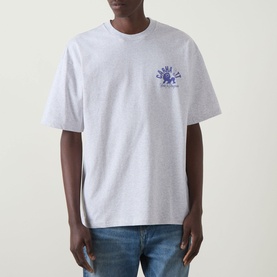 Model wearing Carhartt Built Different Logo T-Shirt in Ash Heather, with blue chest graphic, crew neck, dropped shoulders, styled with blue jeans.