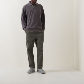 Model wearing Carhartt Harper Heavyweight Polo Shirt in Tobacco, styled with olive chinos and grey trainers