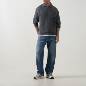 Model wearing Carhartt Harper Logo Half-Zip Sweatshirt in Black, styled with mid-wash straight-leg jeans and grey trainers.