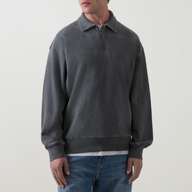 Model wearing Carhartt Harper Logo Half-Zip Sweatshirt in Black, with polo collar and half-zip placket, styled with blue jeans and white tee.