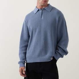 Model wearing Carhartt Shady Blue cotton knit polo with ribbed texture, quarter-zip collar, and relaxed long-sleeve fit