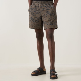 Model wearing Carhartt shorts in Duck Feather camo print with elasticated waist, styled with black leather sandals