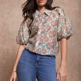 Model wearing Mint Velvet red floral print puff sleeve collared blouse, styled with blue straight-leg jeans