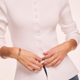 Model wearing Mint Velvet white ribbed button-front top, styled with a gold chain bracelet.