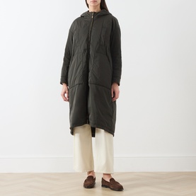 Model wearing Max Mara Cube Bosco Quilted Coat in kaki, hooded longline style with zip front, styled with cream wide-leg trousers and brown loafers.