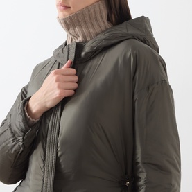 Model wearing Max Mara Cube Bosco Quilted Coat in khaki, hooded style with zip fastening, styled with a ribbed turtleneck