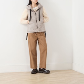 Model wearing Max Mara Cube Greengo Padded Gilet in beige with hood, styled with cream quilted jacket, tan trousers and black loafers.