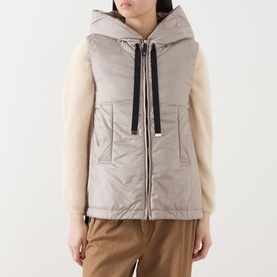 Model wearing Max Mara Cube Greengo Padded Gilet in beige, satin finish, hood with black drawstring, styled with cream shearling-sleeve top