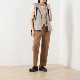 Model wearing Max Mara Cube Greengo Padded Gilet in beige, styled with a cream knit, camel trousers and black chunky loafers.