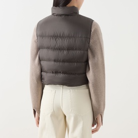 Model wearing Max Mara Cube kaki quilted gilet, back view, styled with beige knit sleeves and cream trousers