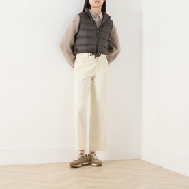 Model wearing Max Mara Cube kaki quilted gilet, styled with cream wide-leg trousers, sheer top, and tan trainers.