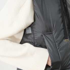 Max Mara Cube green gilet close-up showing dark quilted interior lining with brand label and cream textured outer fabric