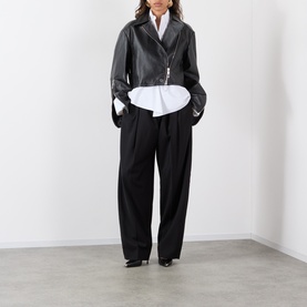 Model wearing Max Mara Sportmax Vicario Fringed Leather Jacket in black, styled with a white shirt and black wide-leg trousers.