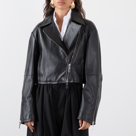 Model wearing Max Mara Sportmax Vicario Fringed Leather Jacket in black, cropped length with asymmetric zip, styled with white shirt and black skirt.