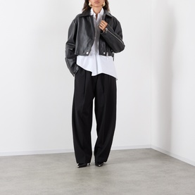 Model wearing Max Mara Sportmax Vicario Fringed Leather Jacket in black, cropped length, styled with white shirt and black wide-leg trousers.
