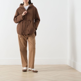 Model wearing Max Mara Cube Charme Reversible Water-Repellent Jacket in hazelnut with drawstring waist and fixed hood, styled with camel trousers