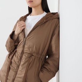 Model wearing Max Mara Cube Charme Reversible Water-Repellent Jacket in hazelnut, featuring fixed hood, zip fastening and drawstring waist.