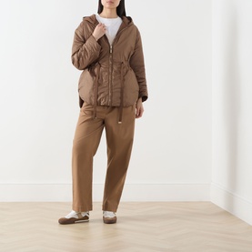 Model wearing Max Mara Cube Charme Reversible Water-Repellent Jacket in hazelnut with fixed hood, styled with matching wide-leg trousers.