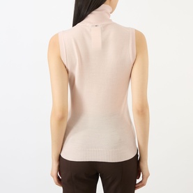 Model wearing Max Mara Sportmax pink sleeveless turtleneck knit top, back view, styled with dark brown trousers