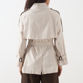 Model wearing Max Mara Cube silver cotton-blend raincoat, rear view showing belted waist, storm flap, and epaulette details.
