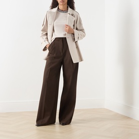 Model wearing Max Mara Cube silver cotton-blend raincoat, styled with white top and brown wide-leg trousers.