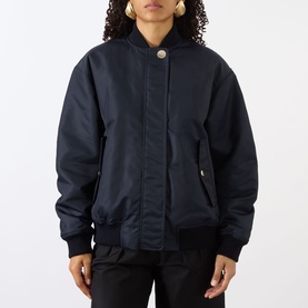 Model wearing Max Mara Sportmax Midnight Blue polyamide bomber-style raincoat with ribbed cuffs, hem, and gold-tone snap collar button.