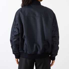 Model wearing Max Mara Sportmax Midnight Blue polyamide bomber-style raincoat, rear view, ribbed cuffs and hem, quilted sleeves