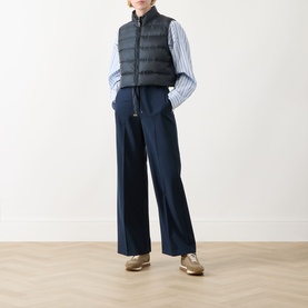 Model wearing Max Mara Cube Favilla Padded Gilet in Midnight Blue, styled with a striped shirt, wide-leg trousers and tan loafers.