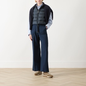Model wearing Max Mara Cube Favilla Padded Gilet in Midnight Blue with wide-leg navy trousers, blue striped shirt and gold trainers.