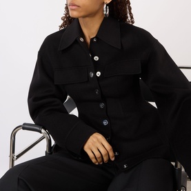 Model wearing Max Mara Sportmax Arena Button-Down Short Coat in black, featuring pointed collar, chest flap pockets and button fastenings, styled