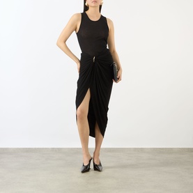 Model wearing Max Mara Sportmax black draped midi skirt with front split, styled with black tank top and black heels, holding clutch bag.