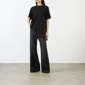 Model wearing Max Mara Sportmax nero cotton top with fringe trim, styled with wide-leg black jeans
