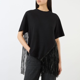 Model wearing Max Mara Sportmax nero cotton T-shirt with long diagonal fringe trim, styled with dark grey jeans.